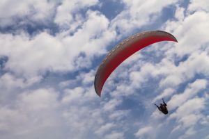 Flying paraglider against a blue sky with white clouds in Buzet.