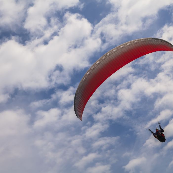 Flying paraglider against a blue sky with white clouds in Buzet.