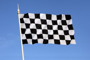 Checkered flag with a black-and-white checkered pattern displayed at the end of a race.