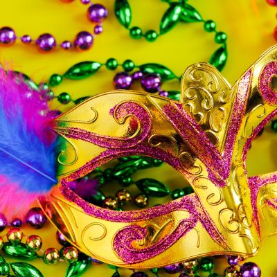 Carnival mask with feathers on a yellow background.