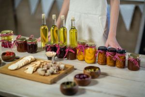 Jars of preserves and bottles of olive oil on a table at a food festival.