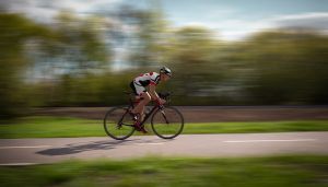 Seitenansicht eines Radfahrers, der mit Geschwindigkeitseffekt Fahrrad fährt.