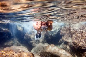 Donna che fa snorkeling nelle acque limpide in Istria, Croazia.