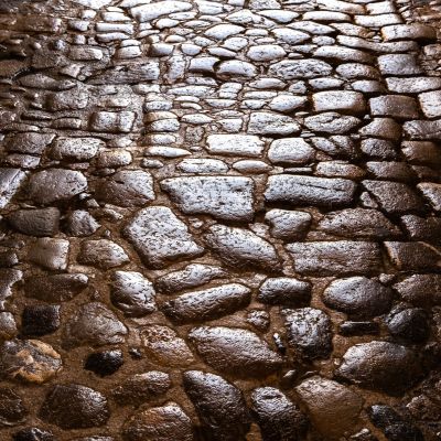 Close-up of ancient Roman cobblestone street, glistening in the light