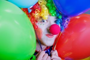 Colorful clown holding balloons at a circus festival