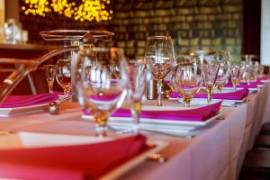 Table à manger élégamment dressée avec des verres à vin et des serviettes violettes à Fažana, mettant en valeur l'expérience gastronomique disponible via istria.holiday et les villas de luxe.