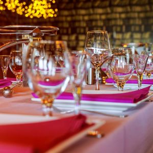 Elegant dining table setup with wine glasses and purple napkins in Fažana, highlighting the gourmet experience available through istria.holiday and luxury villas.