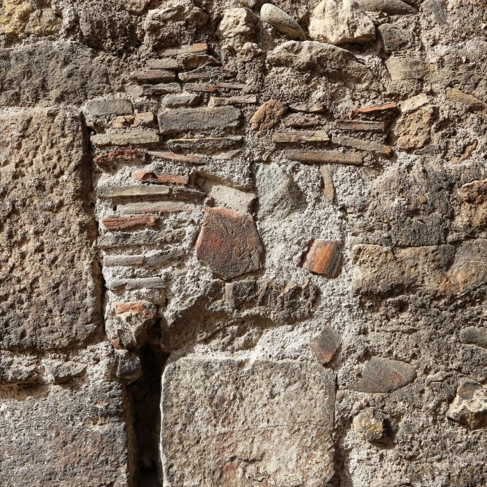 Close-up of an ancient stone wall at Pietrapelosa Castle, showcasing the varied textures and materials used in its construction.